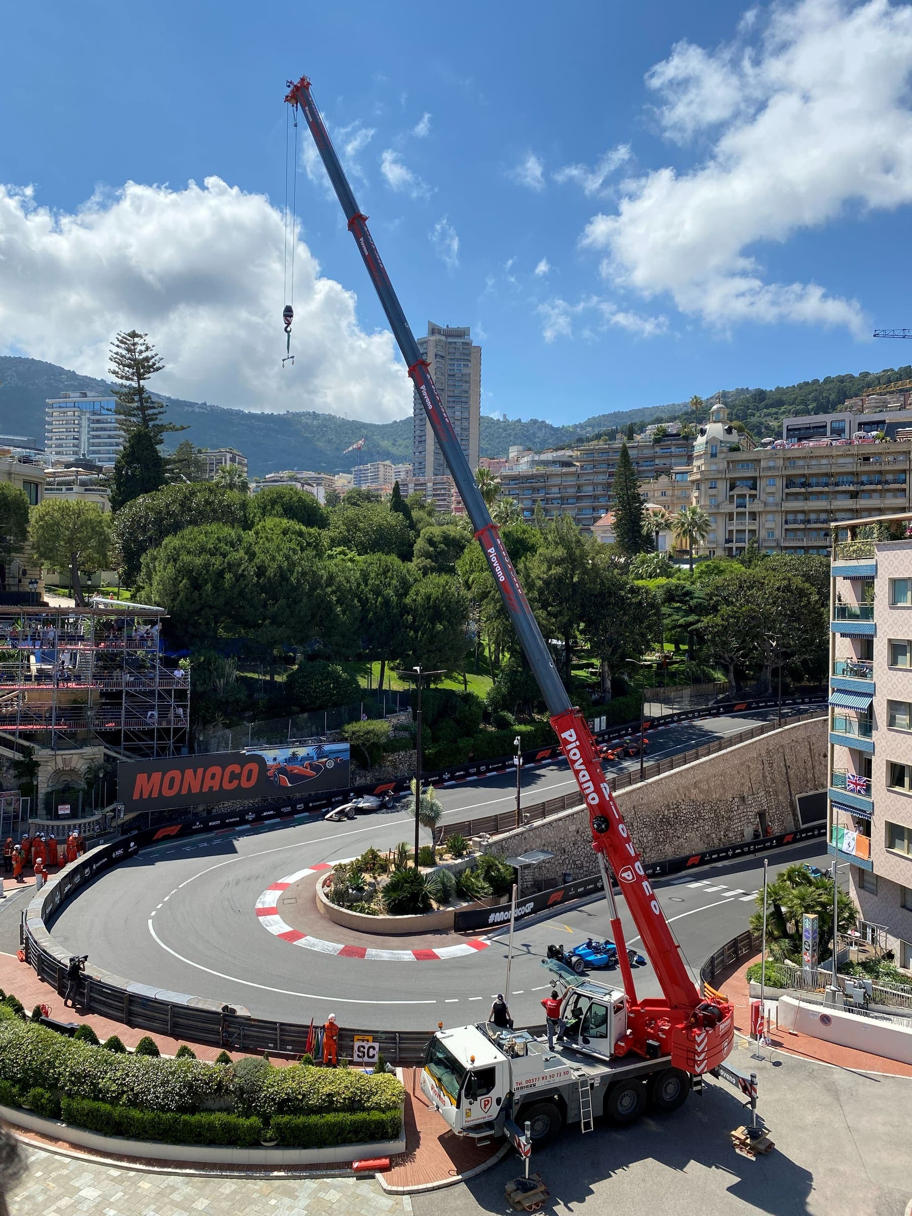 Formula 1 cars through the Monaco hairpin seen from a terrace above the circuit