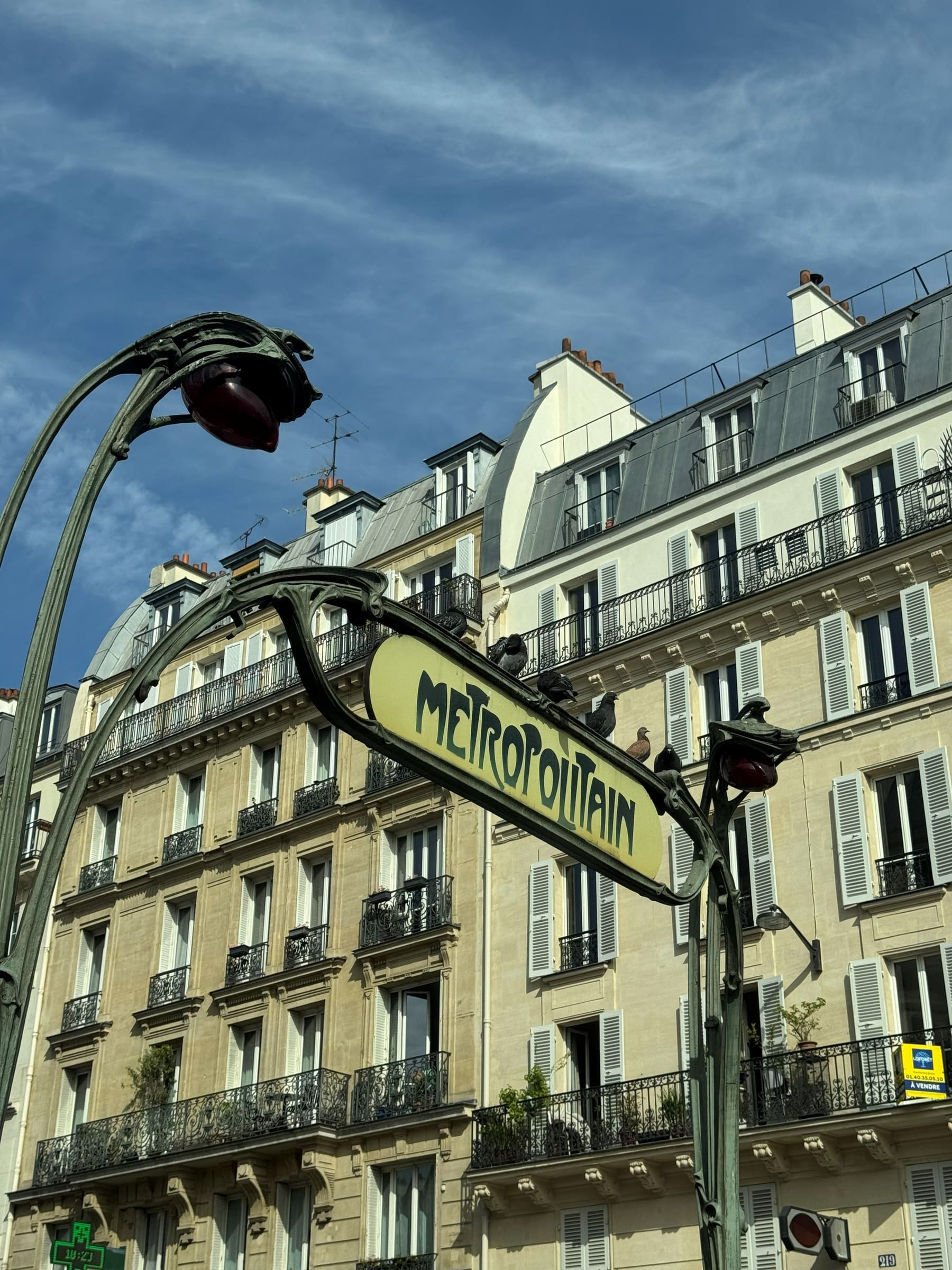 A Métropolitain sign in front of a Haussmann façade