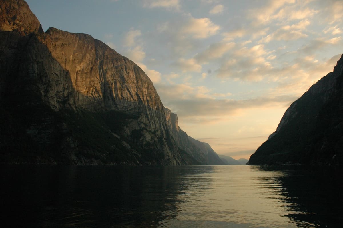 Steep rock walls on both sides of the Lysefjord in evening light, seen from the water